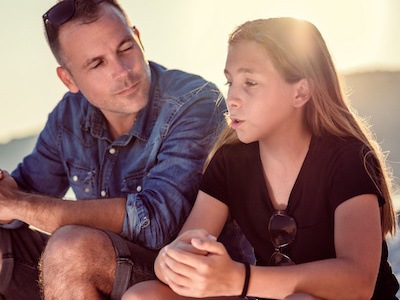 Dad talking to daughter while thinking about reasons to modify child support in Texas