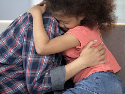 Adoptive mother hugging adopted child wondering if the biological parent can regain custody after adoption
