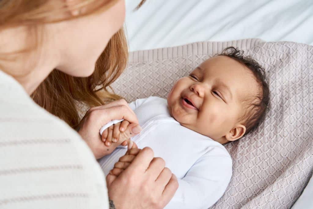 A young mother smiling and laughing with her infant after completing an infant adoption in Texas.