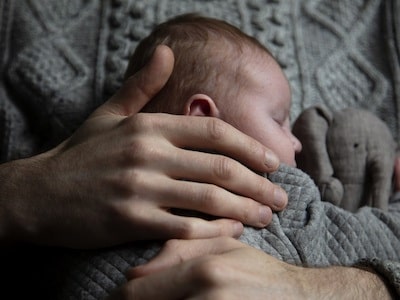 Man holding a child after resolving disputed paternity case in Texas
