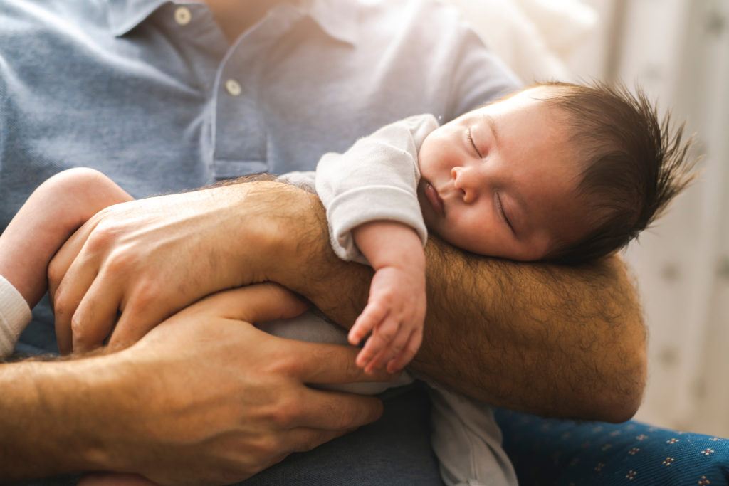 A father holding his child after working with a paternity lawyer