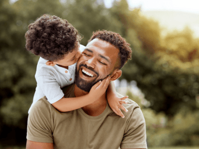 Dad and son smiling at the park
